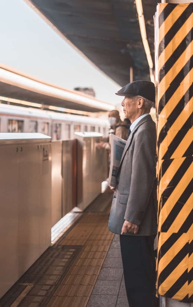 old man standing on train platform
